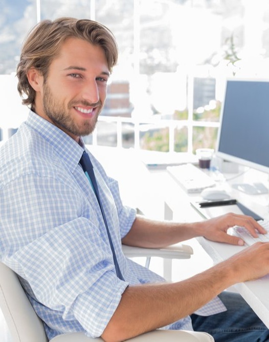 Smiling designer working at his desk in modern office-1-1